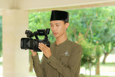 Young man filming with video camera