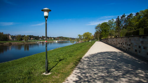 Street by canal against sky