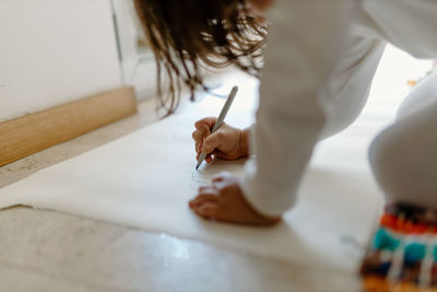 Girl drawing on paper at home