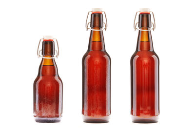 Three corked beer bottles against white background