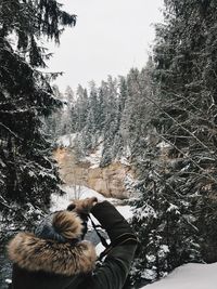 Rear view of man on snowy field against sky during winter