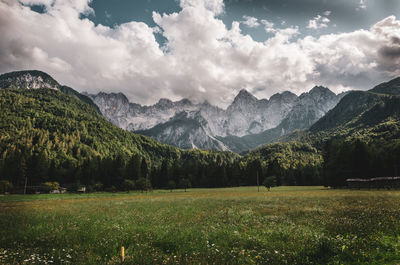 Scenic view of landscape and mountains against cloudy sky