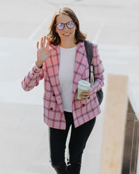 Portrait of young woman standing against wall