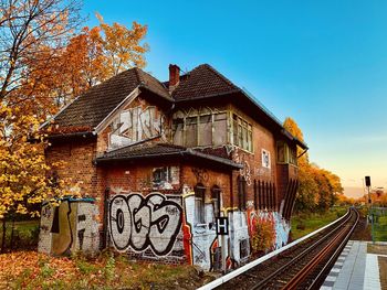 Graffiti on railroad tracks by building against sky