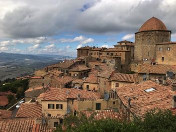 Buildings in town against cloudy sky