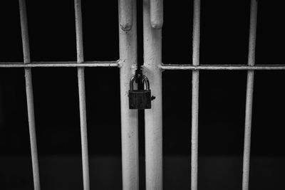 Close-up of padlocks on metal fence against building