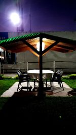 Empty table and chairs at night