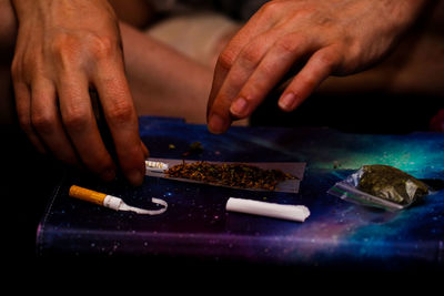 Hands of man making marijuana joint 