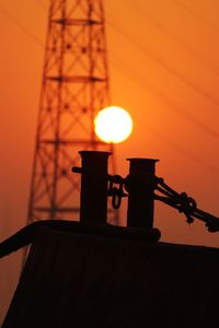 Low angle view of illuminated lamp against orange sky