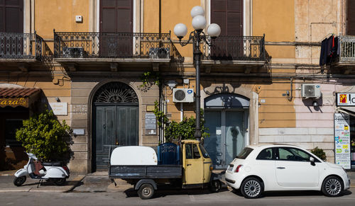 Cars parked on road by buildings in city