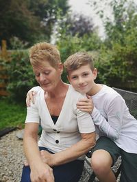 Portrait of boy sitting outdoors with his gran 