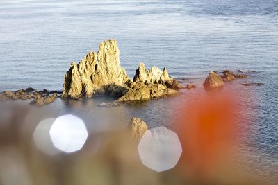 Rock formations on sea shore against sky