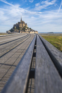 View of railroad tracks by building against sky