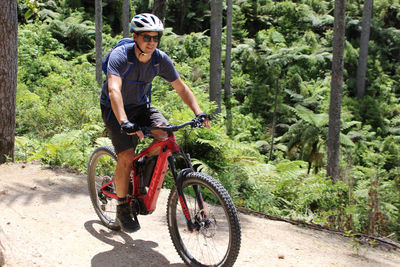 Portrait of man riding bicycle on plants