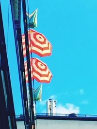 Low angle view of flag against blue sky