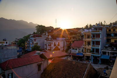 Buildings against sky during sunset in town