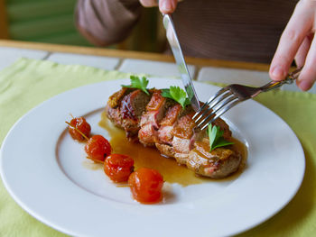 Close-up of person preparing food in plate