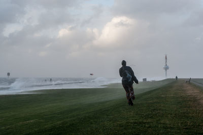 Man on grassy field against sky