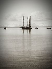 Distance shot of built structure in calm sea