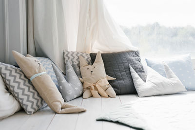 Children's colorful pillows in pastel colors. pillows in the form of a bunny and a bear on the bed 