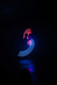 Low angle view of illuminated lighting equipment against black background