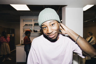 Portrait of young man with friends in background at college dorm