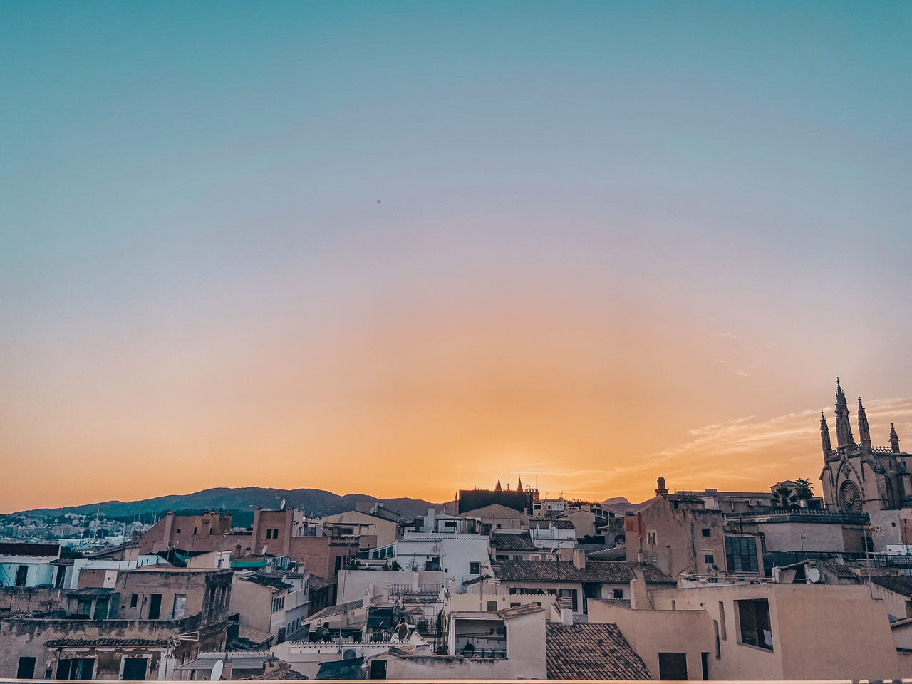 HIGH ANGLE SHOT OF TOWNSCAPE AGAINST ORANGE SKY