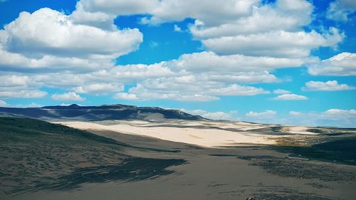 Scenic view of beach against cloudy sky