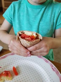 Midsection of boy holding food at table