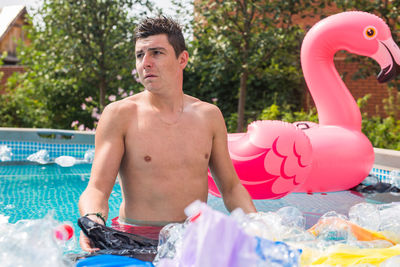 Midsection of shirtless man in swimming pool