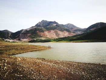 Scenic view of lake and mountains against clear sky