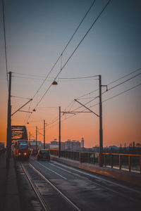 Cars on road against sky during sunset