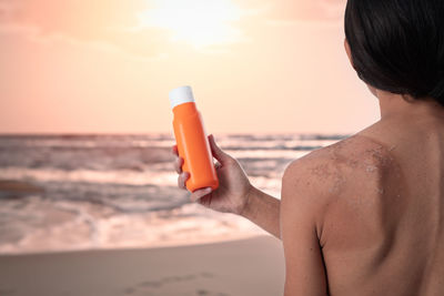 Rear view of woman drinking water