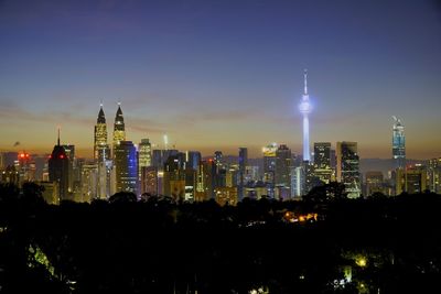 Illuminated cityscape against sky at night
