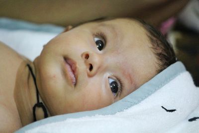 Portrait of cute baby lying on bed