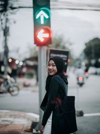 Woman standing on road in city