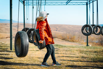 Side view of man playing at outdoor play equipment in autumn