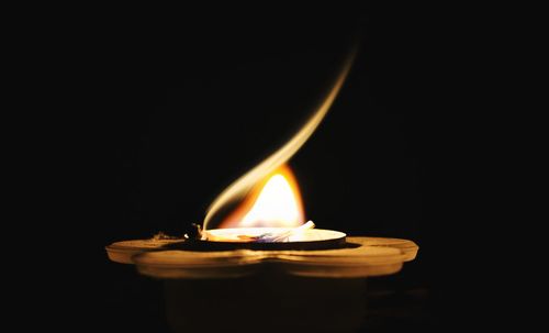 Close-up of illuminated lamp against black background