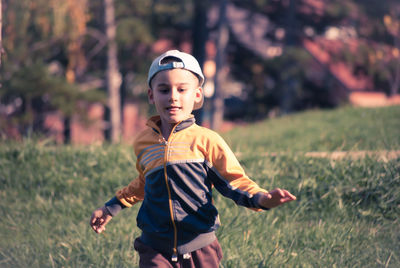 Boy running on grassy field at park