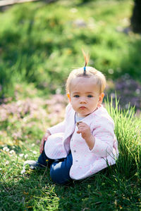 Portrait of cute girl sitting on field