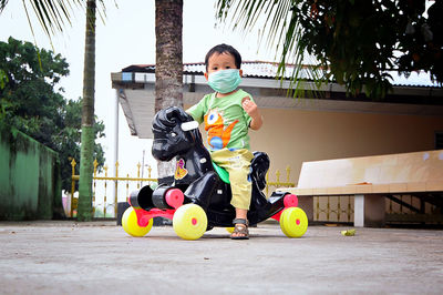 Portrait of boy wearing mask sitting on rocking horse