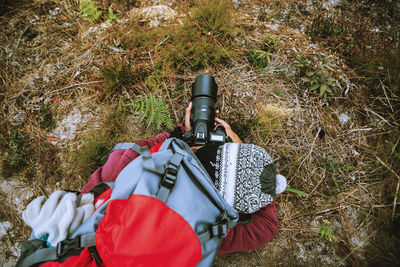 High angle view of woman photographing plants in forest