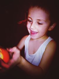 Smiling girl playing with toy in darkroom