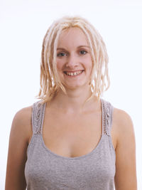 Portrait of smiling young woman against white background