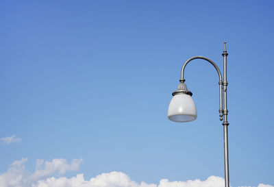 Low angle view of street light against blue sky