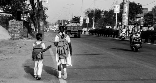 Two school children walking at roadside