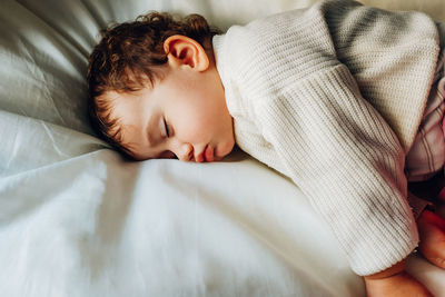 High angle view of cute baby girl sleeping on bed