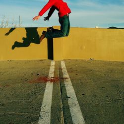 Low section of man skateboarding on road