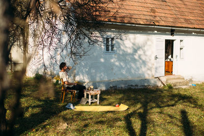 A man seats in front of his house in a small village