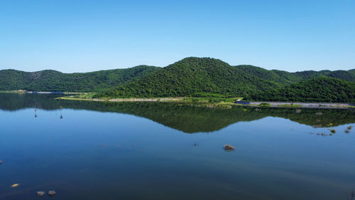 Scenic view of lake against clear blue sky